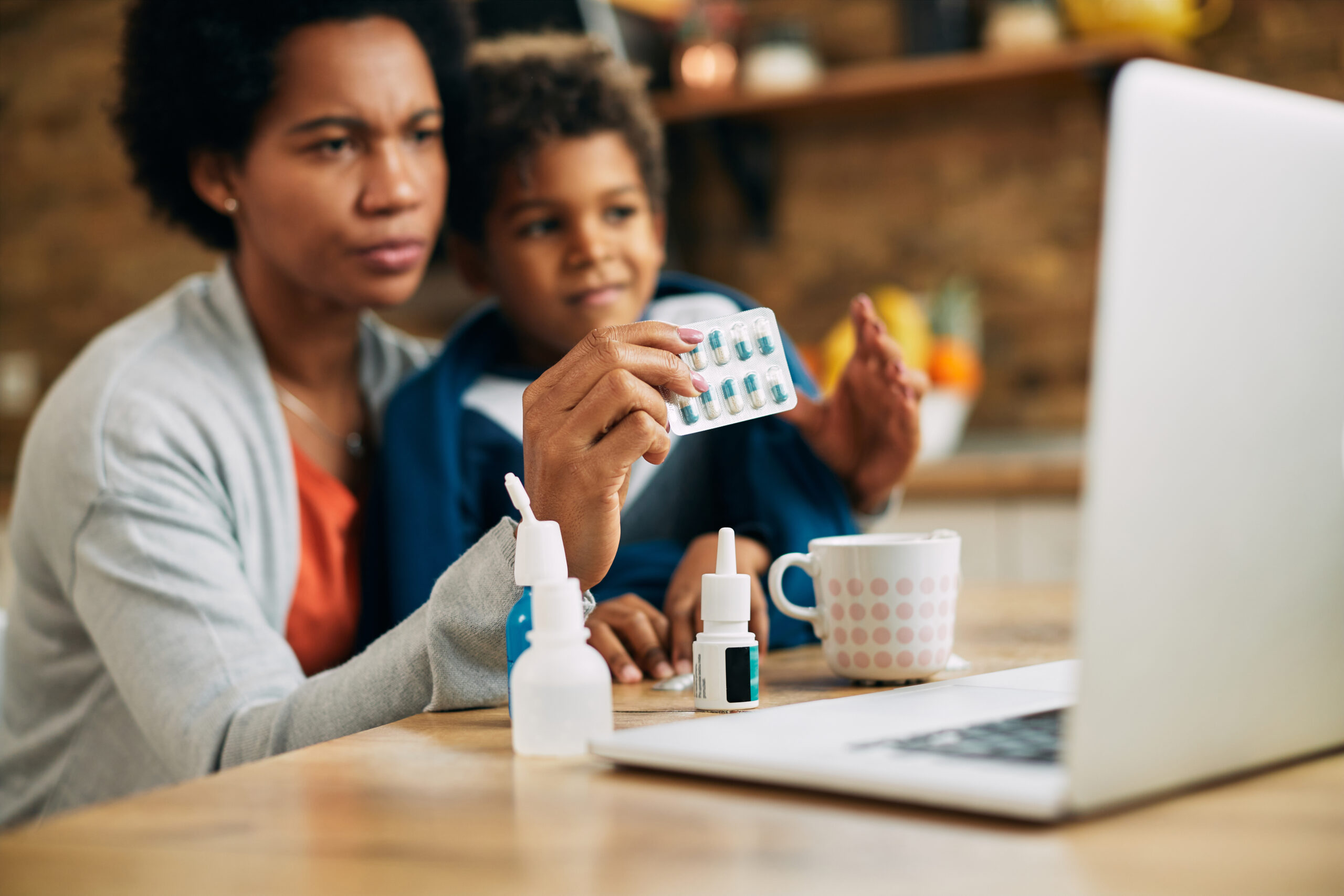closeup black mother consulting with doctor online about medicine her son scaled