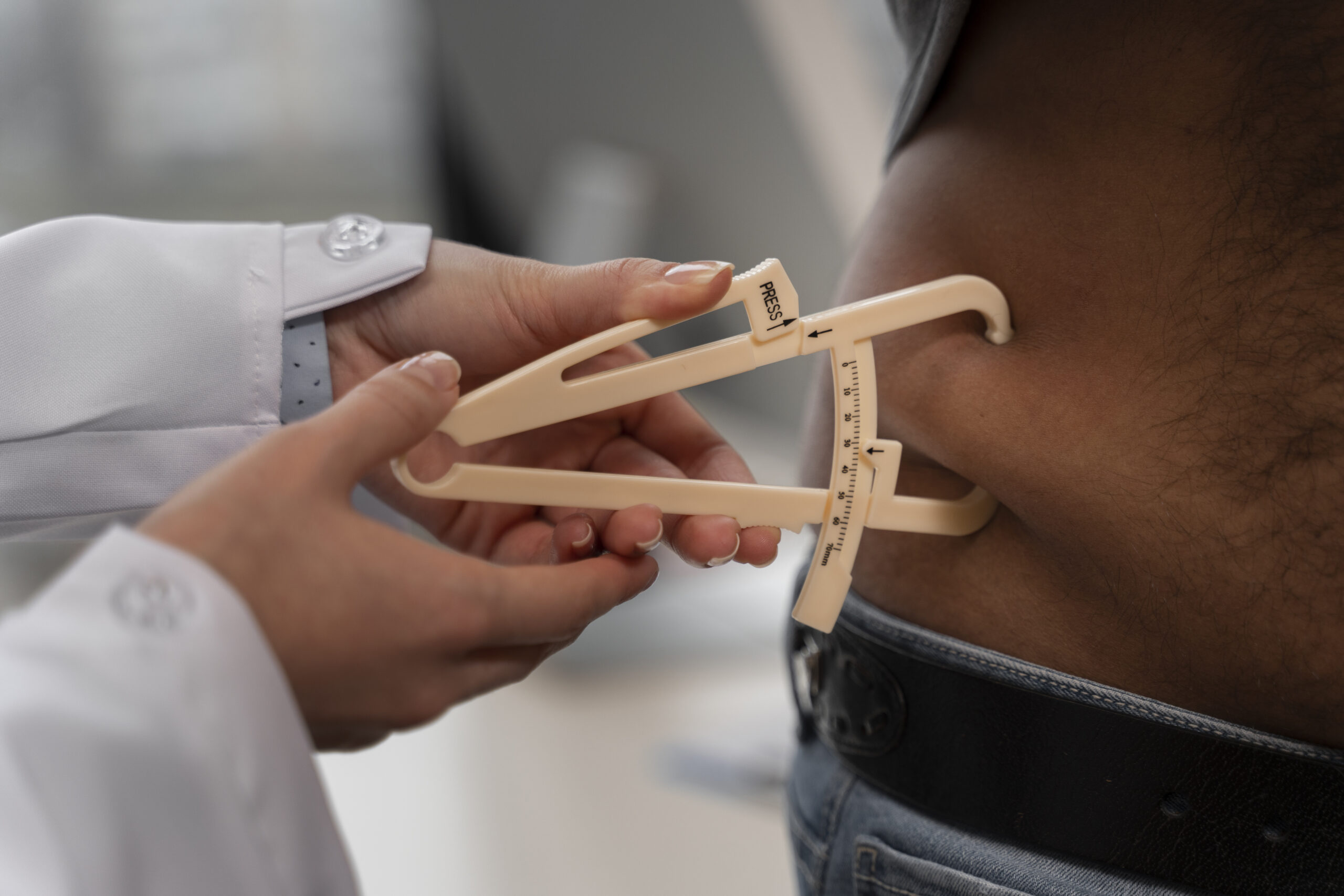 front view doctor using adipometer scaled