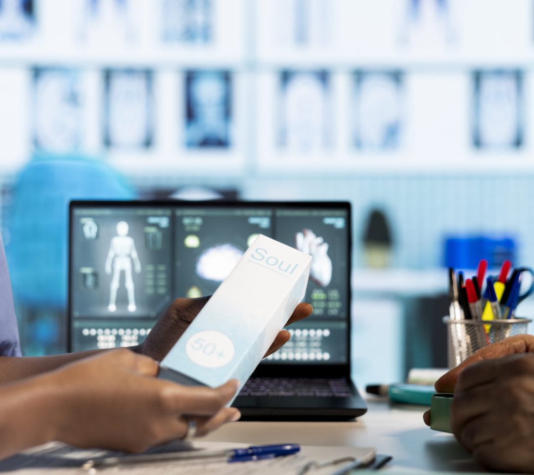 African american medical assistant highlights collagen rich cosmetics for skin treatment and repair, demonstrating expert care and advice in a healthcare office. Professional hydration. Close up.